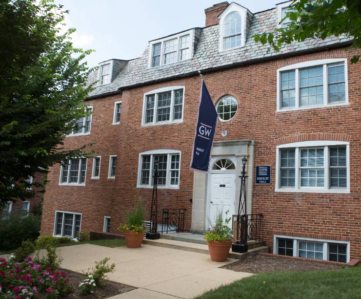 Hensley Hall, a red brick building with a GW flag over the door, as seen from the front.