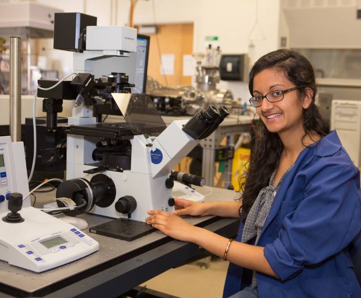 A student sits at a microscope.