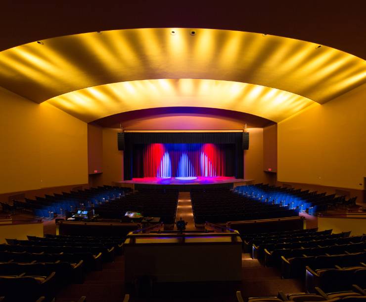 Seats, stage, and lighting of Lisner Auditorium's interior as viewed from the back of the house.