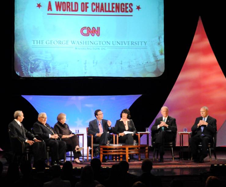 Secretaries Albright, Baker, Christopher, Kissinger and Powell sit talking onstage with Frank Sesno and Christiane Amanpour.
