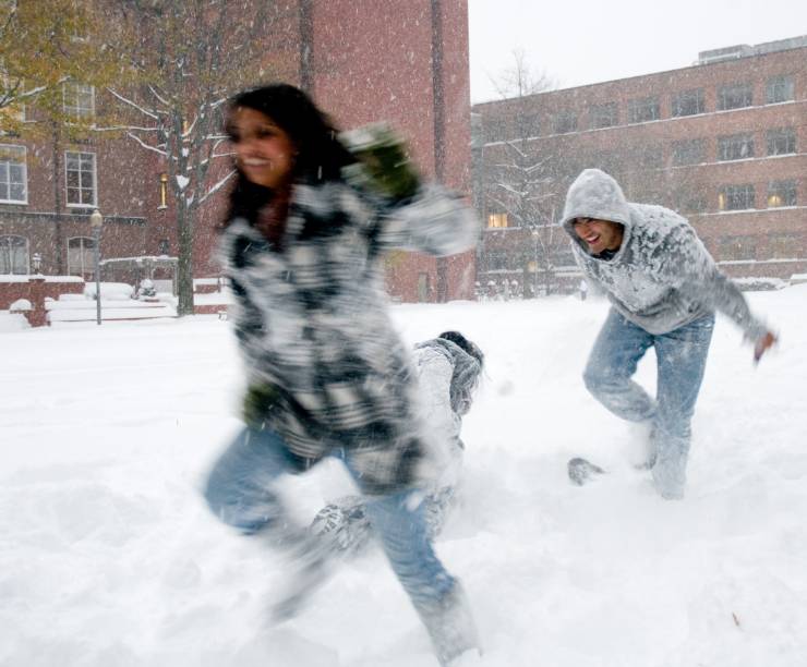Students run in the snow-covered yard.