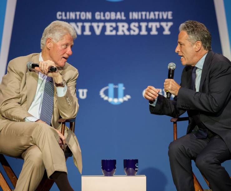President Clinton and Jon Stewart speak onstage.