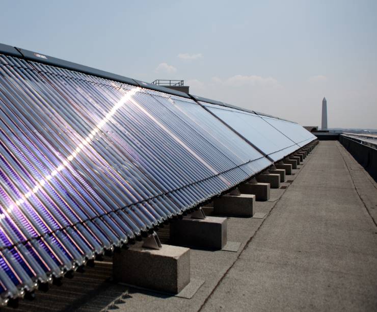 Solar panels line the roof with a view of the Washington Monument in the distance.