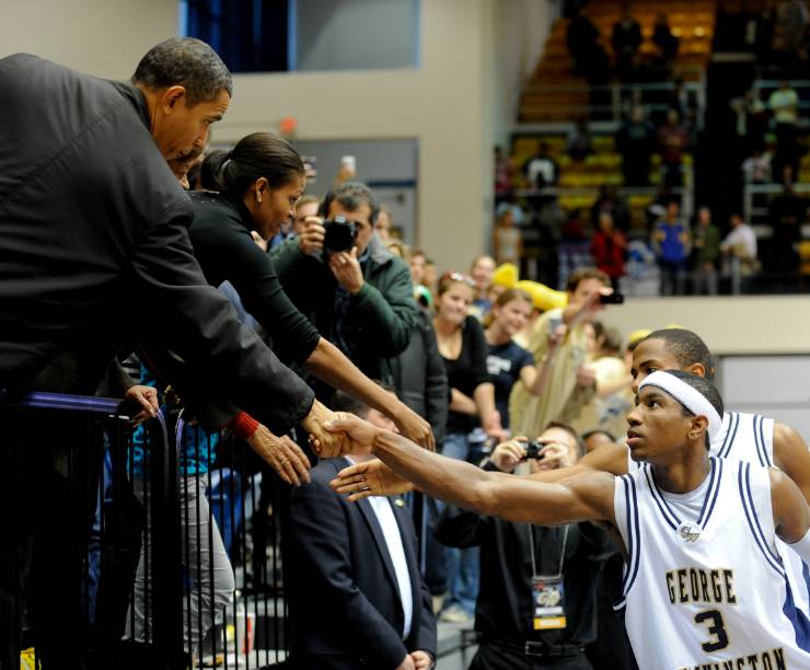 Men's basketball players shake hands with former President Obama.