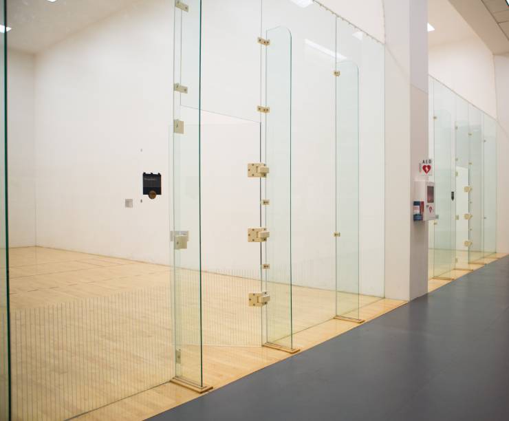 Two racquetball suites with glass walls and a viewing area in front.