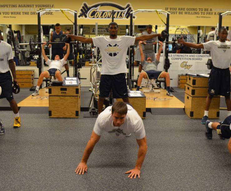 Student athletes workout using weights and equipment.