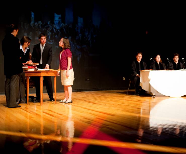 Students perform in a play onstage.