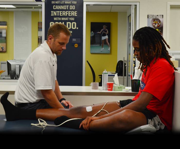 A therapists works with a student athlete.