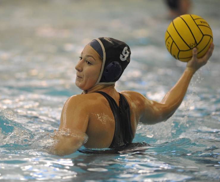 A water polo player in the pool prepares to throw the ball.