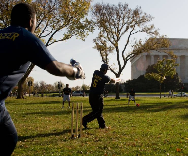 Students play cricket near the Lincoln Memorial.