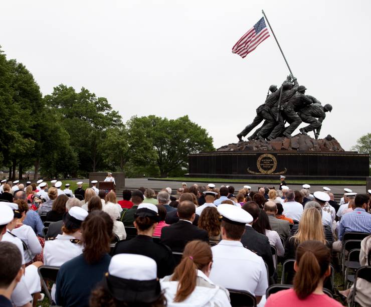 A crowd is seated in front of the Iwo Jima Memorial.