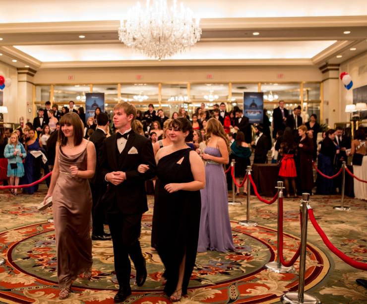 Students in formal dress enter the hotel party.