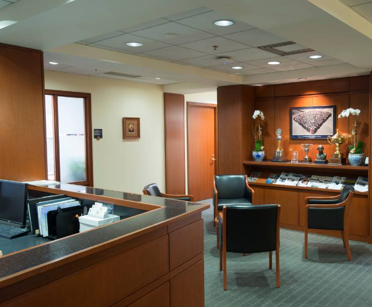 Front desk of the GW Law Dean's office with chairs for guests. Statues and publications are lined up on shelves by the chairs.