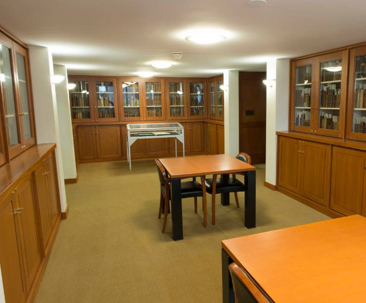 GW Law's Rare Reading Room features tables and chairs and glass-enclosed books in shelves.