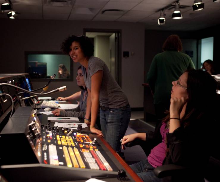 Students work the control board in a studio.