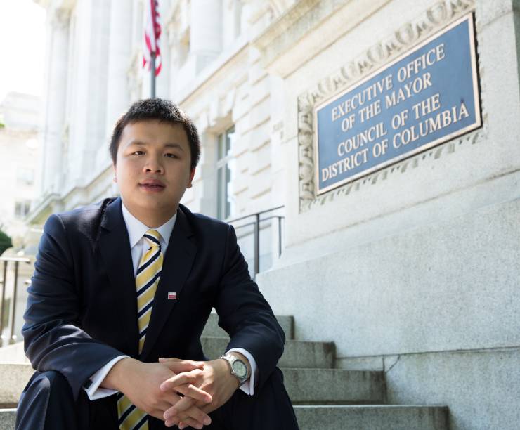 A student sits on the steps of the Office of the Deputy Mayor of D.C.