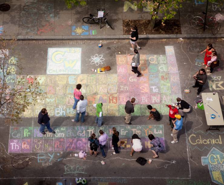 Students draw in chalk on the H Street pavement.