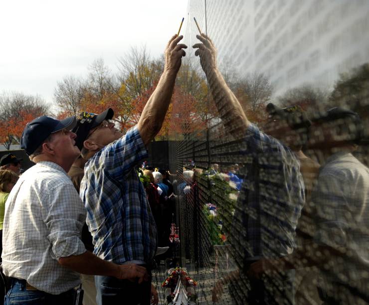 Two men read the names on the Vietnam War Memorial.