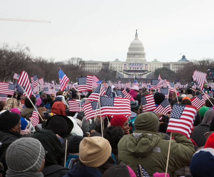 A crowd waves flags in front of the Capitol during the Inauguration.
