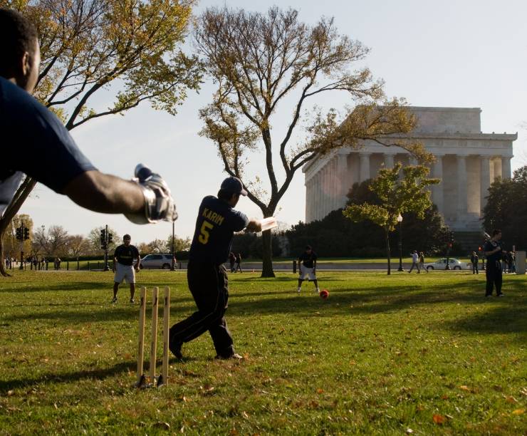 Students play cricket near the Lincoln Memorial.