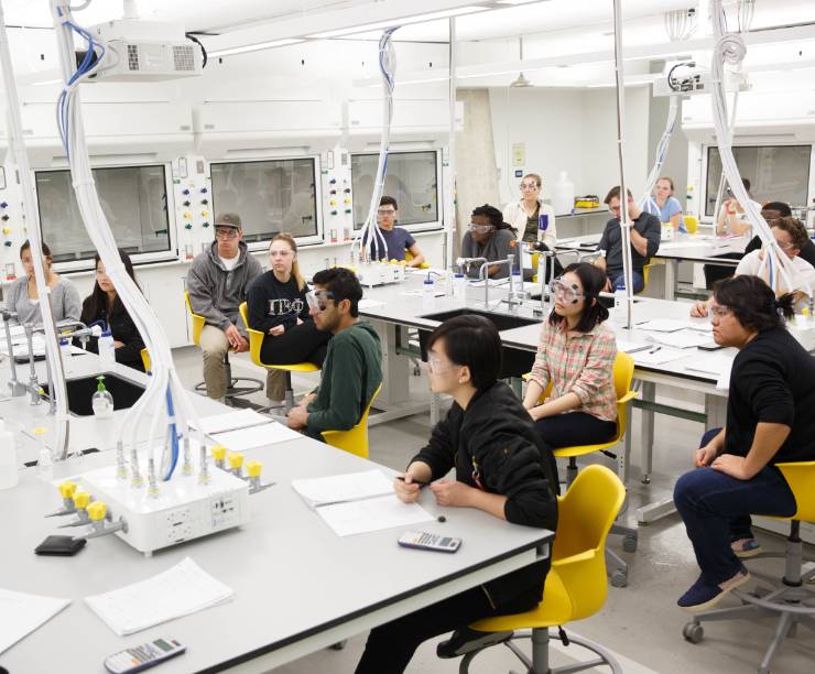 Group of students sit attentively in a lab classroom.