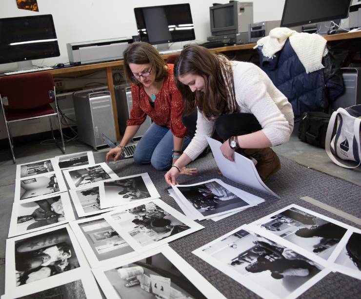A student and her teacher review an array of photographs.
