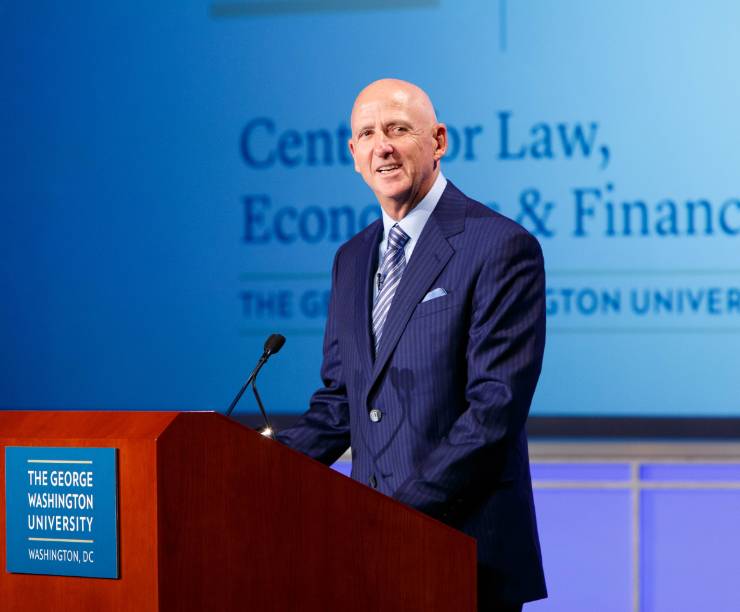 David Falk is seated onstage in front of an audience.