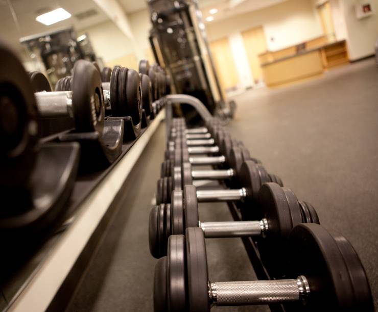 Free weights line a mirrored wall in the fitness center.