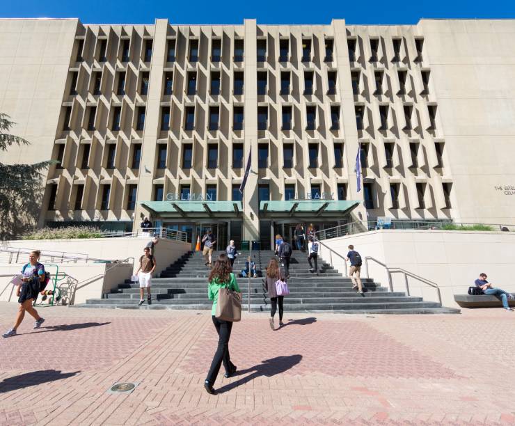 People walk in and out of the front entrance to Gelman Library.